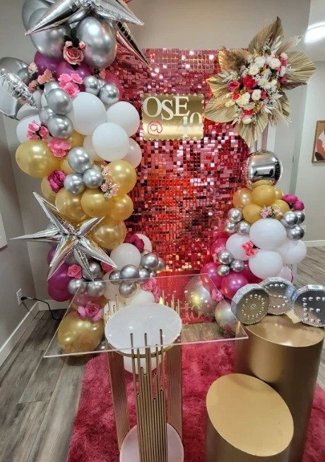 Pink shimmer wall birthday backdrop with gold, white and silver balloons